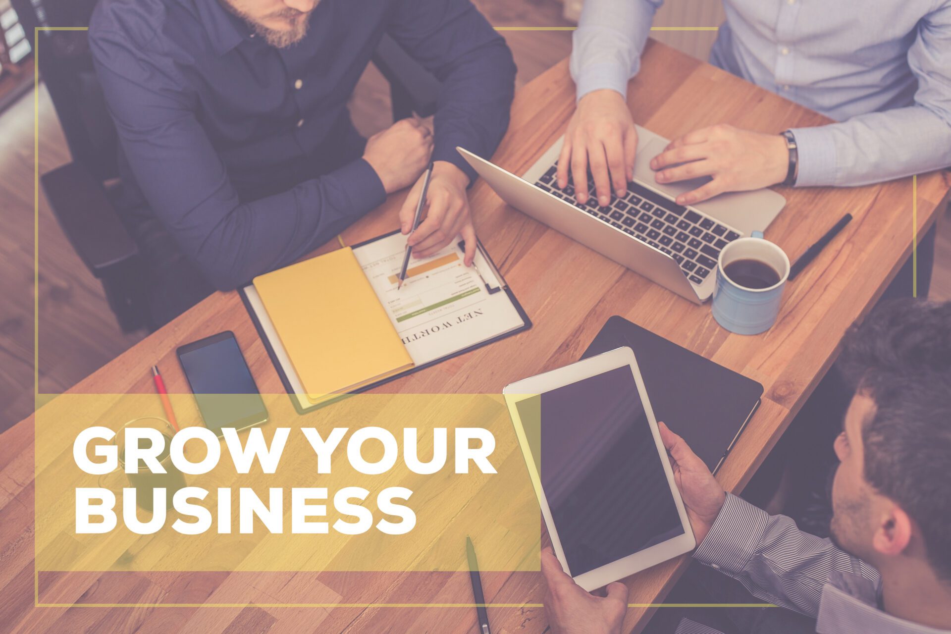 The phrase “Grow Your Business” is superimposed on an image of a marketing team at work.